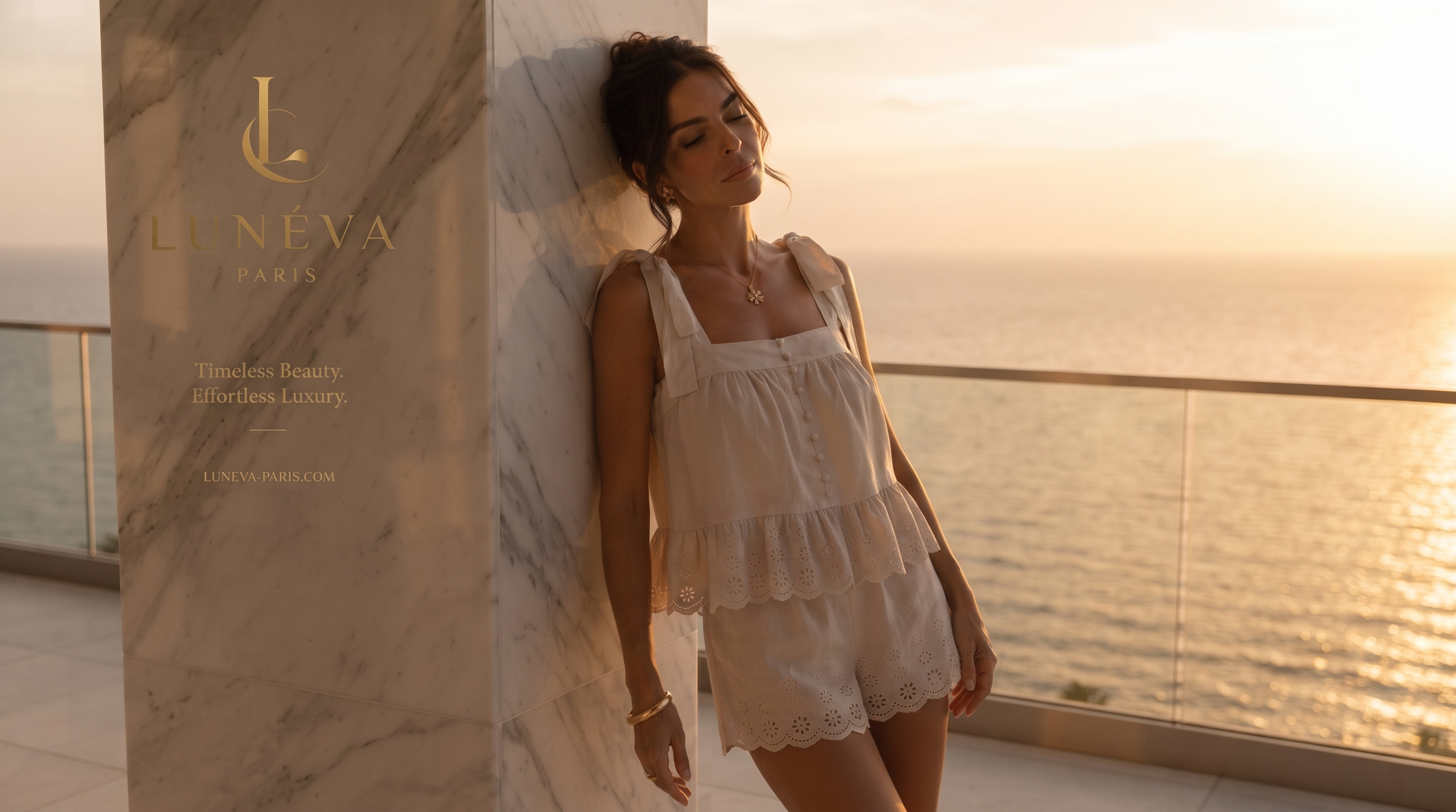 Golden-hour campaign image on a balcony wearing the cream top